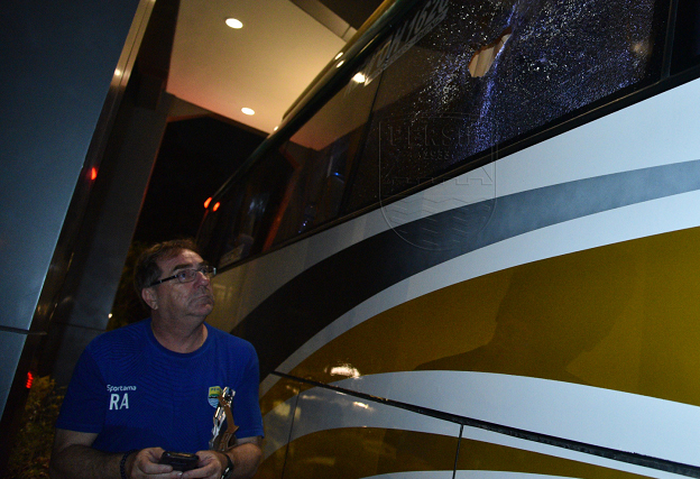 Pelatih Persib Bandung, Robert Alberts, memperhatikan kaca bus yang hancur.