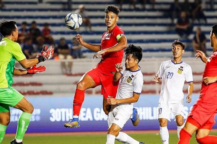 Kapten timnas U-22 Singapura, Irfan Fandi, saat berebut bola dengan pemain Laos pada cabor sepak bola SEA Games 2019.