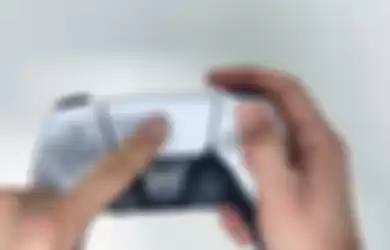 Ilustrasi orang memegang kontroler DualSense PS5