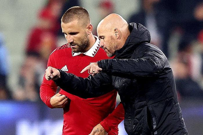 Pelatih Man United, Erik ten Hag (kanan), saat berbicara dengan bek sayap Luke Shaw. Man United dikritik punya pertahanan selembek tim zona degradasi, Ten Hag menilai pesepak bola bukan robot yang bisa tampil bagus di setiap pertandingan.