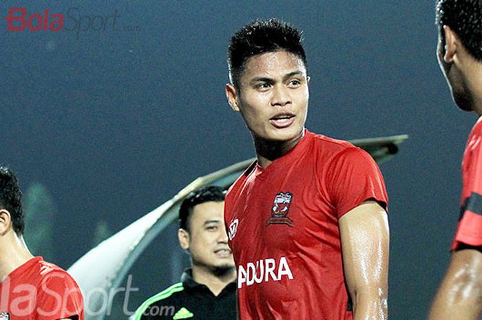   Pemain belakang Madura United, Fachruddin Aryanto (tengah), berbicara dengan rekan setimnya.