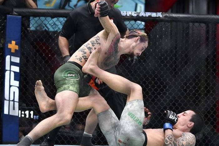 Aksi Bintang Baru, Sean O'Malley (berdiri) memberi pukulan penghabisan ke arah, Thomas Almeida (tiduran) pada UFC 260.