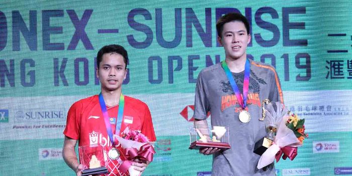 Pebulu tangkis tunggal putra Indonesia, Anthony Sinisuka Ginting bersama Lee Cheuk Yiu dalam penyerahan trofi pada Hong Kong Open 2019, 17 November 2019.