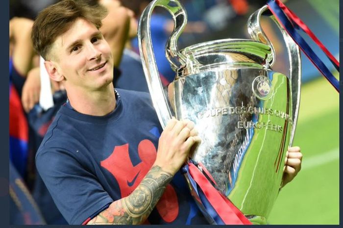 Lionel Messi berpose dengan trofi Liga Champions yang diraih Barcelona.