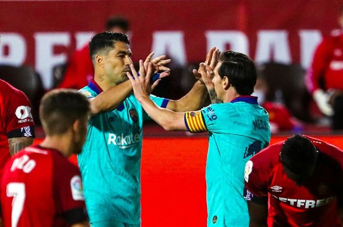 Luis Suarez (kiri) dan Lionel Messi (kanan) merayakan gol Barcelona di menit-menit akhir laga melawan Real Mallorca di Stadion Son Moix, Palma de Mallorca, dalam laga perdana mereka setelah kembalinya Liga Spanyol yang tehenti karena pandemi virus corona pada Minggu (14/6/2020) dini hari WIB.