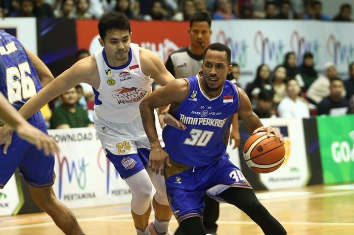 Pemain asing BPD DIY Bima Perkasa Jogja, David Seagers, berupaya melewati penjagaan pemain Satria Muda Pertamina Jakarta, Vamiga Michel, pada laga penutup Seri VII IBL Pertamax 2018-2019 di GOR Bima Sakti, Malang, Jawa Timur, Minggu (10/2/2019).