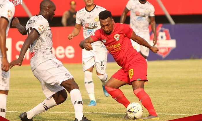 Striker Kalteng Putra, Patrich Wanggai, berusaha melewati pemain bertahan Tira-Persikabo, Zoubairou, pada laga pekan ke-29 Liga 1 2019.