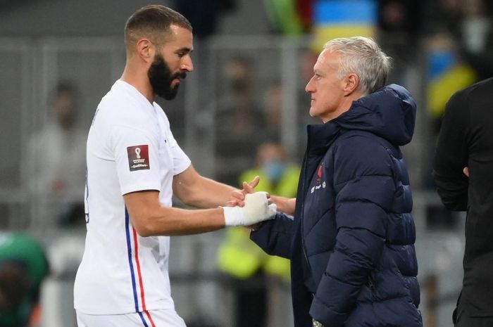 Karim Benzema (kiri) dan pelatih timnas Prancis, Didier Deschamps, bersalaman saat laga melawan Ukraina di Kiev (4/9/2021). Benzema akan absen di Piala Dunia 2022.