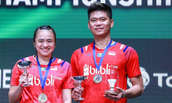 Pasangan ganda campuran Indonesia, Praveen Jordan (kanan)/Melati Daeva Oktavianti, berpose di atas podium kampiun All England Open 2020, di Arena Birmingham, Inggris, Minggu (15/3/2020).