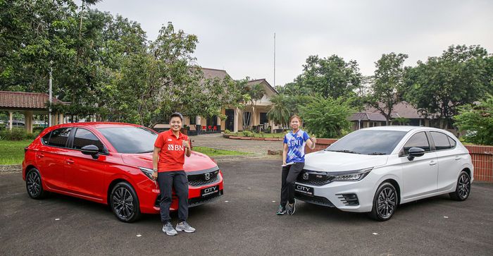 Pasangan ganda putri Indonesia, Greysia Polii (kaos biru) dan Apriyani Rahayu, berpose di depan mobil baru mereka yang merupakan apresiasi dari Honda terhadap prestasi mereka meraih medali emas Olimpiade Tokyo 2020.