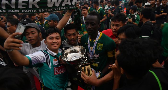 Pemain Persebaya Surabaya, Makan Konate, saat merayakan gelar juara Piala Gubernur Jatim 2020 di tengah kerumunan suporter Persebaya, Bonek, di Stadion Gelora Delta Sidoarjo, Kamis (20/2/2020).