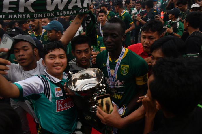 Pemain Persebaya Surabaya, Makan Konate, saat merayakan gelar juara Piala Gubernur Jatim 2020 di tengah kerumunan suporter Persebaya, Bonek, di Stadion Gelora Delta Sidoarjo, Kamis (20/2/2020).