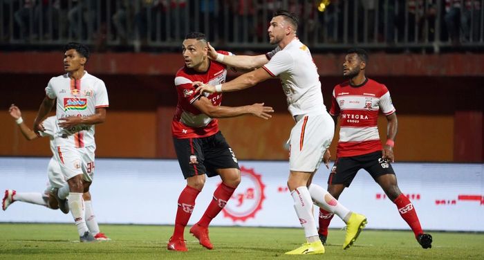 Striker Persija Jakarta, Marko Simic, mendapatkan pengawalan ketat dari bek Madura United, Jaimerson Xavier, pada laga pekan ke-14 Liga 1 2019.