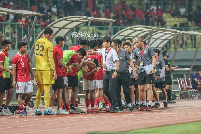 Pelatih timnas U-19 Indonesia, Shin Tae-yong (kemeja putih), yang ditemani para asistennya nampak bersalaman dengan pemain-pemainnya di Stadion Patriot Candrabhaga, Bekasi, Jawa Barat, 8 Juli 2022.