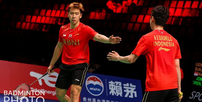 Pasangan ganda putra Indonesia, Marcus Fernaldi Gideon/Kevin Sanjaya Sukamuljo, melakukan tos di sela pertandingan melawan wakil Thailand, Supak Jomkoh/Kittinupong Kedren, pada lanjutan penyisihan Grup A Thomas Cup 2020 di Ceres Arena, Aarhus, Denmark, Senin (11/10/2021).