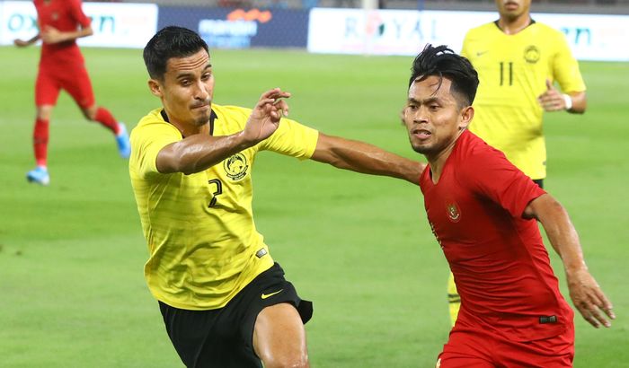 Pemain Timnas Indonesia Andik Vermansah berebut bola dengan pemain Timnas Malaysia pada ajang kualifikasi Piala Dunia Qatar 2022 di Stadion Utama Gelora Bung Karno, Jakarta, Kamis (5/9/2019). 