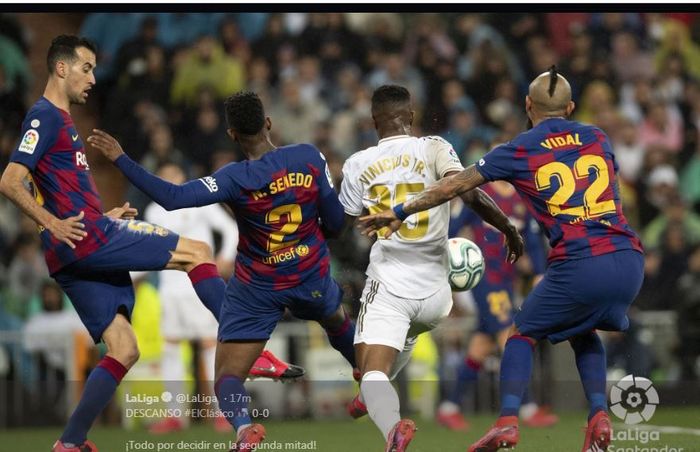 Perebutan bola antara Vinicius Jr dengan para pemain Barcelona dalam partai el clasico Real Madrid vs Barcelona di Santiago Bernabeu dalam lanjutan Liga Spanyol, 1 Maret 2020.