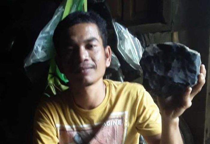 Josua Hutagalung (33) warga Dusun Sitahan Barat, Desa Satahi Nauli, Kecamatan Kolang, Kabupaten Tapanuli Tengah menunjukkan batu yang diduganya sebagai meteor setelah jatuh menimpa rumahnya, Sabtu (1/8/2020).