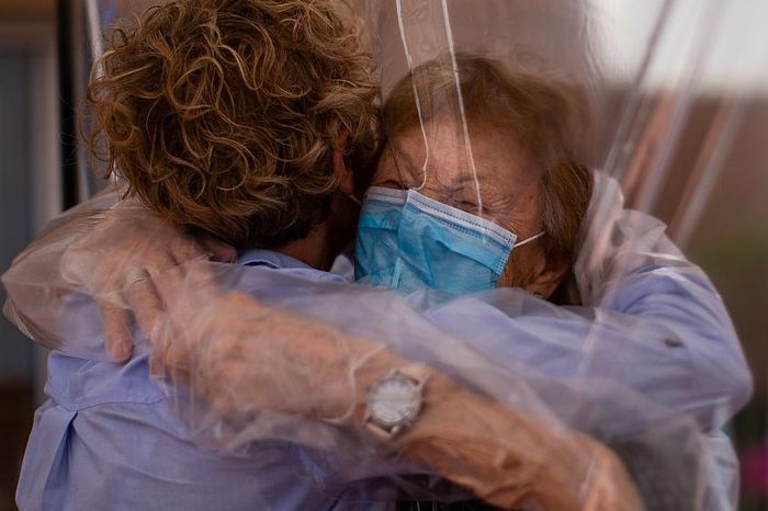 abel P&eacute;rez L&oacute;pez, 96, menerima pelukan melalui layar film plastik dari putrinya yang berkunjung, Beatriz Segura, 67 di panti jompo di Barcelona, Spanyol.