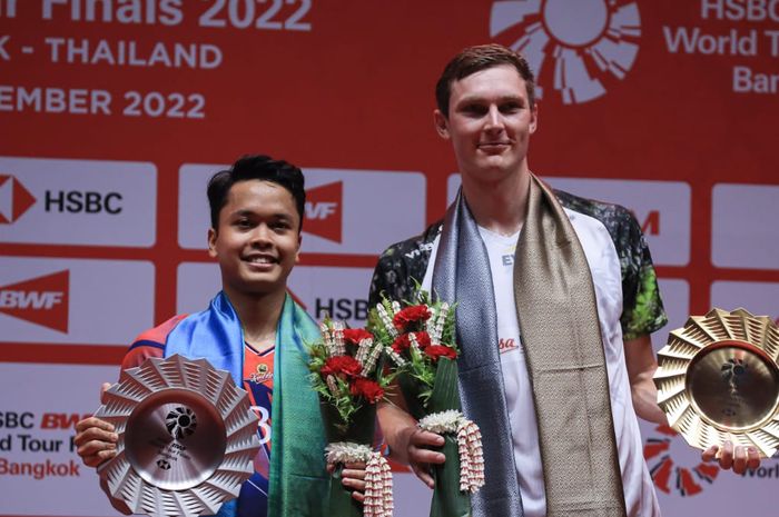 Tunggal putra Indonesia, Anthony Sinisuka Ginting (kiri) dan Viktor Axelsen dari Denmark (kanan) berdiri di podium BWF World Tour Finals 2022, Nimibutr Stadium, Bangkok, Thailand, Minggu (11/12/2022).