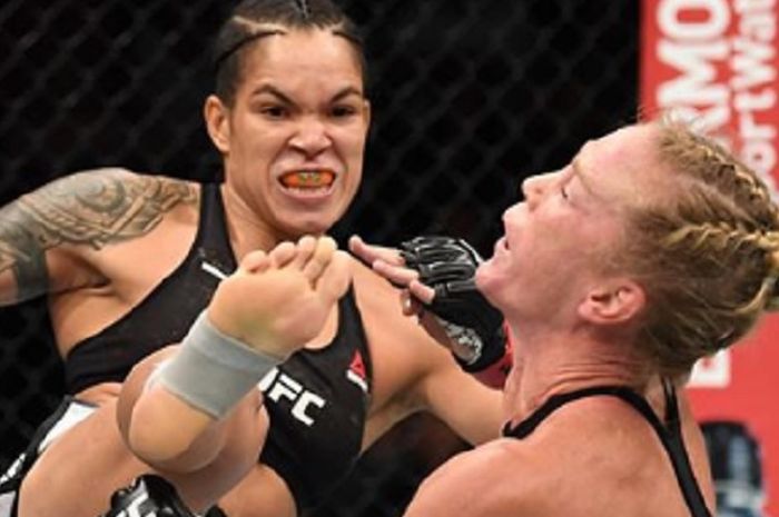 Momen saat Holly Holm (kanan) mendapat tendangan dari Amanda Nunes (kiri) yang membuatnya kemudian dinyatakan kalah TKO pada duel UFC 239, Sabtu (6/7/2019) malam waktu AS