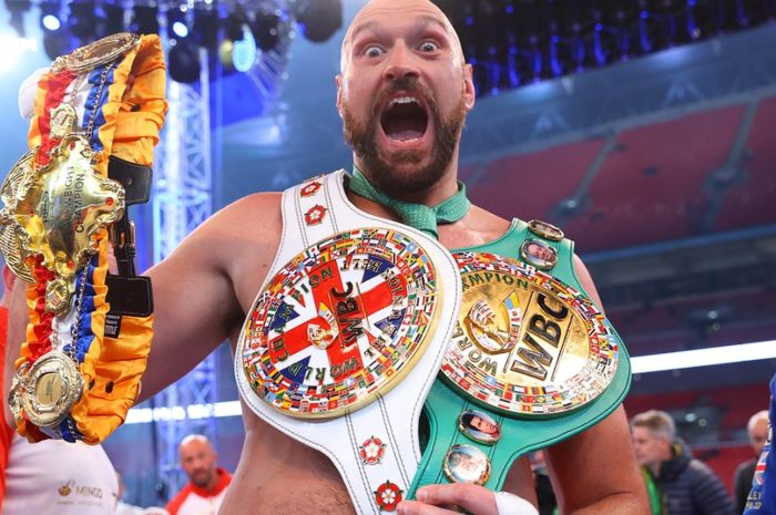 Tyson Fury berpose bersama sabuk-sabuk juara yang dimenangkannya.