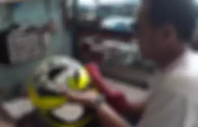 Rifa, Pegawai Bengkel Helm sedang meng-coating helm AGV milik pelanggan.