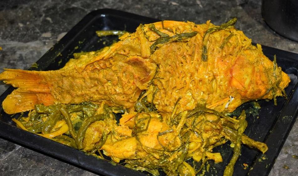 Hidangan arsik ikan mas khas Batak dengan bumbu rempah lengkap dan warna kuning keemasan yang menggugah selera