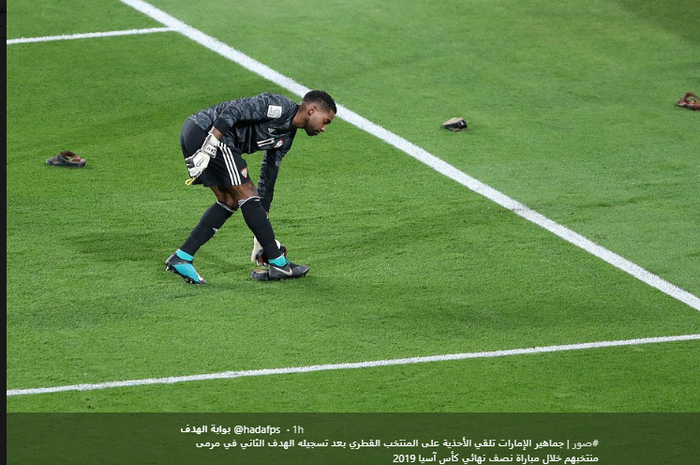Kiper Uni Emirat Arab, Khalid Essa memunguti sepatu, botol dan sandal yang dilemparkan suporter UEA pada laga semifinal l Piala Asia 2019 di Stadion Hazza Bin Zayed, Selasa (29/1/2019).