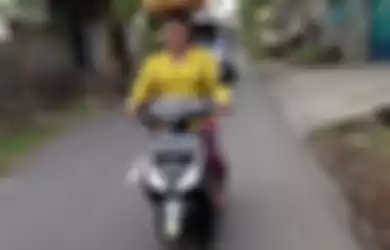 Bawa tumpukan buah diatas kepala sambil mengendarai motor