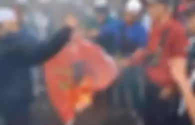 Tangkap layar video aksi pembakaran bendera PDIP oleh massa PA 212 di Jakarta. 