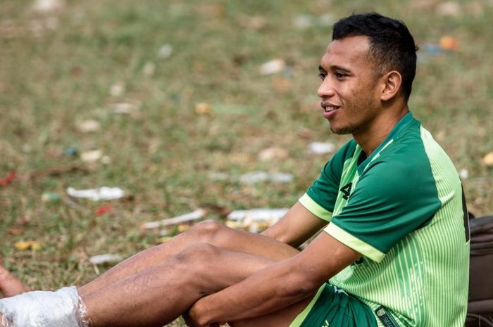 Winger Persebaya Surabaya, Irfan Jaya, mendapatkan perawatan sembari menyaksikan rekan-rekannya menjalani recovery training di Lapangan Bromo Kalinegoro Mertoyudan, Magelang, Minggu (21/9/2019).