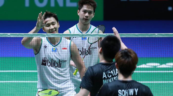 Pasangan ganda putra Indonesia, Marcus Fernaldi Gideon/Kevin Sanjaya Sukamuljo, bersalaman dengan Aaron Chia/Sooh Woi Yik (Malaysia) pada perempat final All England Open 2020 di Arena Birmingham, Inggris, Jumat (13/3/2020).