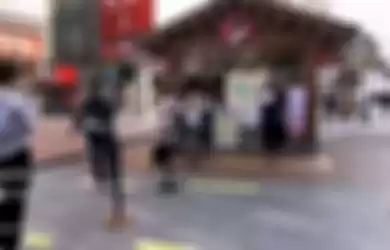 Orang-orang Cina mengantri dengan tetap menjaga jarak 1 meter