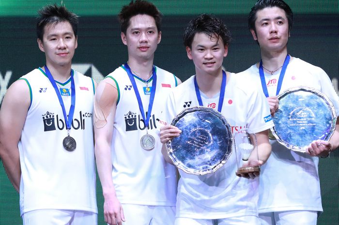 Pasangan ganda putra Indonesia, Marcus Fernaldi Gideon/Kevin Sanjaya Sukamuljo (kiri), berpose bersama Hiroyuki Endo/Yuta Watanabe (Jepang) di atas podium kampiun All England Open 2020,  Arena Birmingham, Inggris, Minggu (15/3/2020).