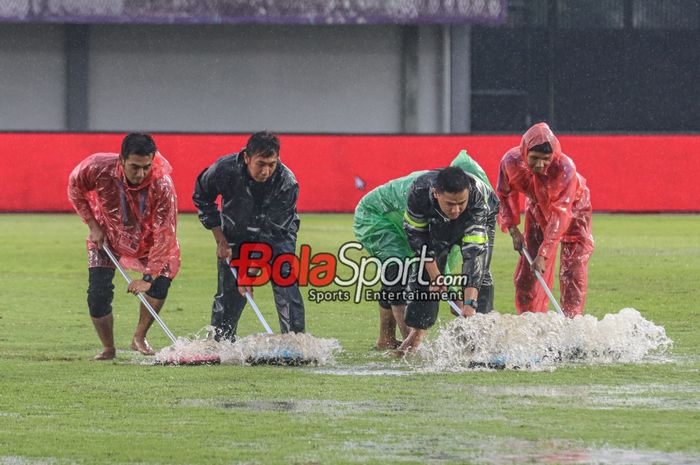 Ilustrasi petugas sedang membereskan genangan air yang menggenang seusai Laga pekan ke-22 Liga 1 2023 antara Dewa United versus Bali United sempat terpaksa ditunda sementara karena cuaca hujan dan petir di Stadion Indomilk Arena, Tangerang, Banten, Jumat (8/12/2023).