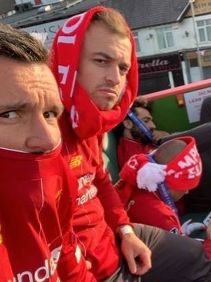 Dejan Lovren (kiri) dan Xherdan Shaqiri (tengah) terlihat kebingungan saat Mohamed Salah (kanan) tertidur ketika parade juara Liverpool.