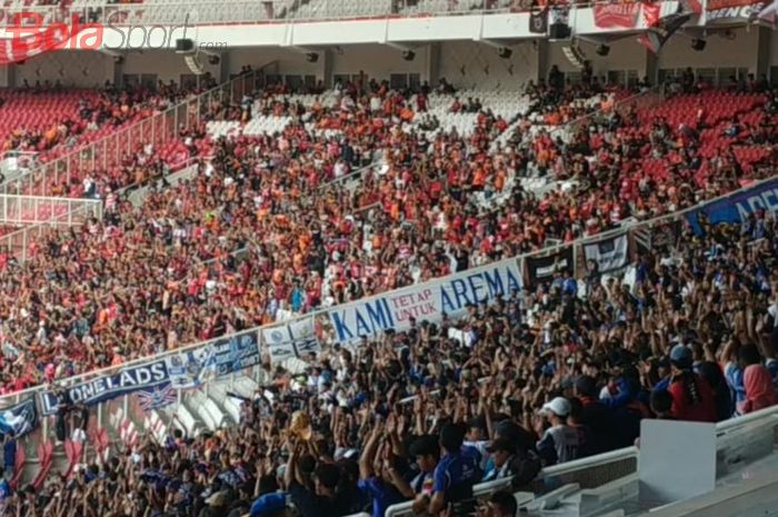 Aremania (biru) dan The Jakmania (oranye) berdampingan mendukung timnya masing-masing, Arema FC dan Persija Jakarta di Stadion Utama Gelora Bung Karno (SUGBK), Sabtu (3/8/2019).