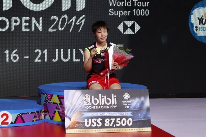 Pebulu tangkis tunggal putri Jepang, Akane Yamaguchi, berpose di podium kampiun Indonesia Open 2019 setelah memenangi laga final atas Pusarla Venkata Sindhu (India) di Istora Senayan, Jakarta, Minggu (21/7/2019).