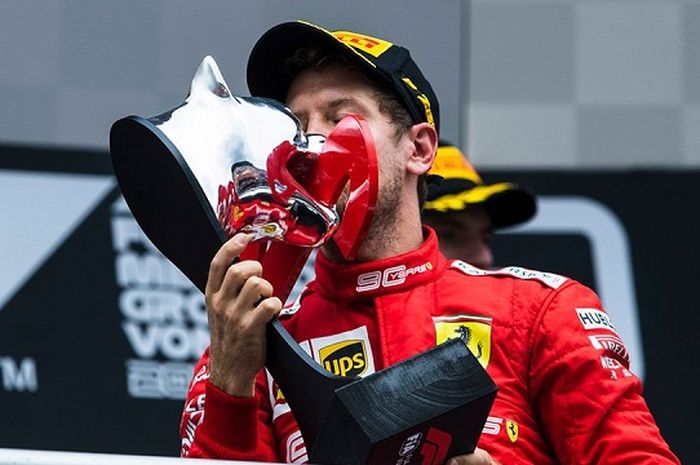 Sebastian Vettel (Ferrari) saat mencium trofi yang ia dapatkan setelah finis sebagai runner up F1 GP Jerman 2019, Minggu (28/7/2019)