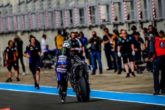 Aksi Maverick Vinales saat mendorong motornya menuju ke garasi tim Yamaha pada FP2 MotoGP Prancis 2019.