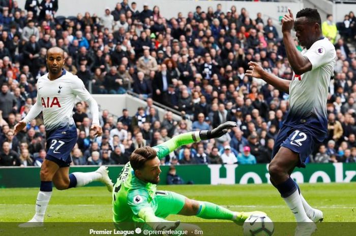 Gelandang Tottenham Hotspur, Victor Wanyama (kanan), memperdayai kiper Huddersfield Town, Ben Hamer, dalam laga pekan ke-34 Liga Inggris di Tottenham Hotspur Stadium, 13 April 2019.