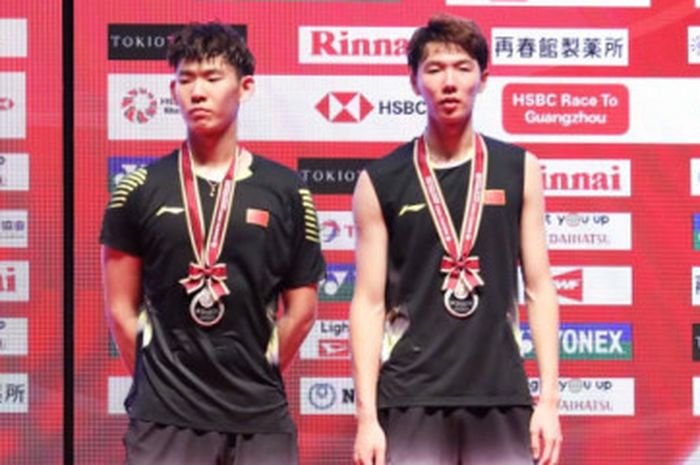 Pasangan ganda putra Indonesia, Marcus Fernaldi Gideon/Kevin Sanjaya Sukamuljo (kiri),  dan lawan mereka, Li Jun Hui/Liu Yu Chen, (China),  berpose setelah final Japan Open 2018.
