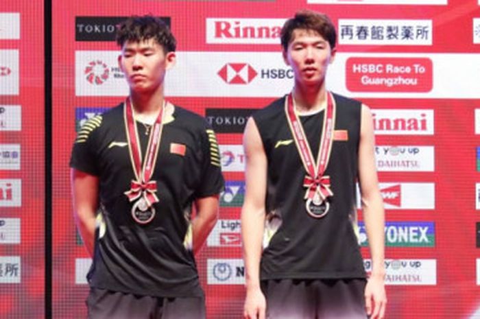 Pasangan ganda putra Indonesia, Marcus Fernaldi Gideon/Kevin Sanjaya Sukamuljo (kiri),  dan lawan mereka, Li Jun Hui/Liu Yu Chen, (China),  berpose setelah final Japan Open 2018.