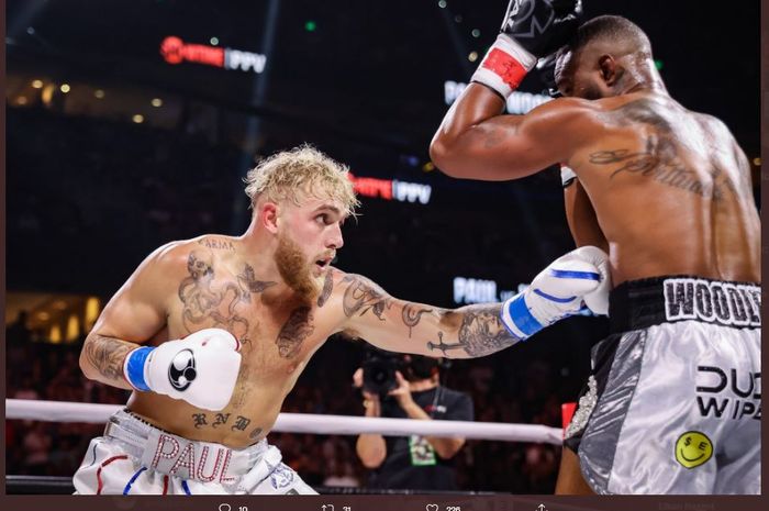 Momen Jake Paul (kiri) melakukan body shot ke arah Tyron Woodley (kanan) dalam duel ulang antara mereka berdua di Amalie Arena, Tampa, Florida, Amerika Serikat, Sabtu (18/12/2021).