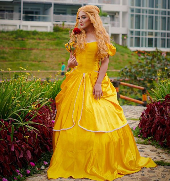 Ashanty memakai gaun ala Princess Belle di taman.
