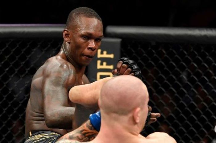 Aksi Israel Adesanya (kiri) menyepak Marvin Vettori (kanan) dalam UFC 263 Minggu (13/6/2021).