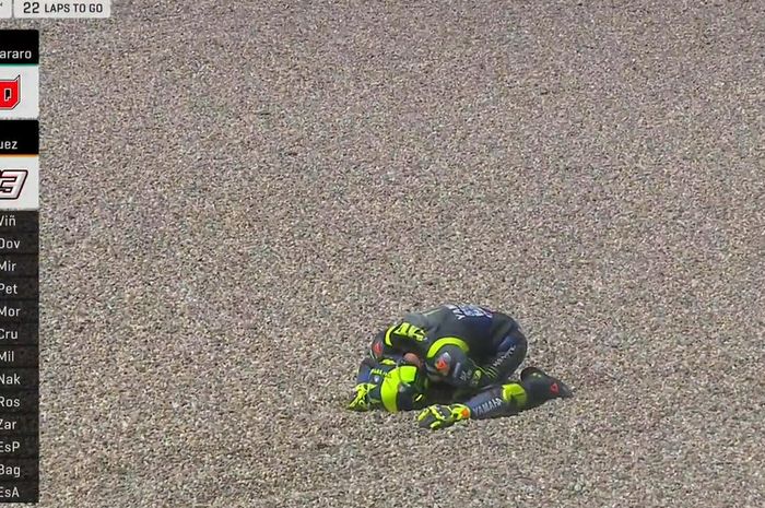 Momen saat Valentino Rossi meringkuk di area gravel Sirkuit Assen setelah mengalami insiden pada sesi balapan GP Belanda 2019, Minggu (30/6/2019)