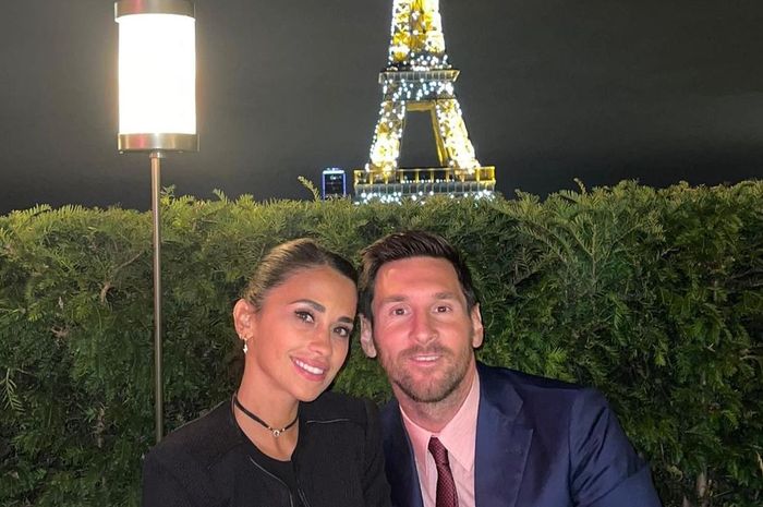 Megabintang PSG, LIonel Messi bersama istrinya, Antonela Roccuzzo sedang menikmati makan malam romantis dengan latar belakang Menara Eiffel di Kota Paris.