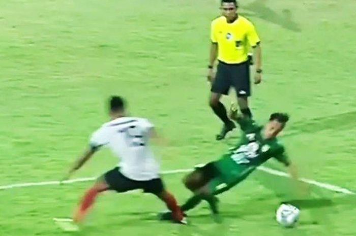 Wasit Agus Fauzan berada tepat di depan insiden pelanggaran striker Persebaya, Samsul Arif.